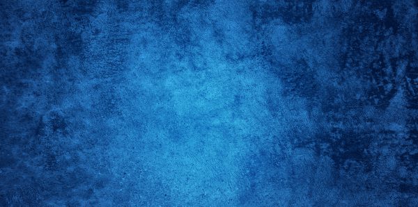 Abstract Grunge Decorative Relief Navy Blue Stucco Wall Texture. Wide Angle Rough Colored Background With spot light